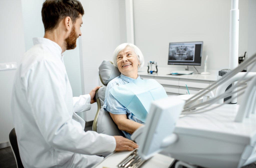 Happy patient talking to dentist to learn about tips to take care of her dental crown