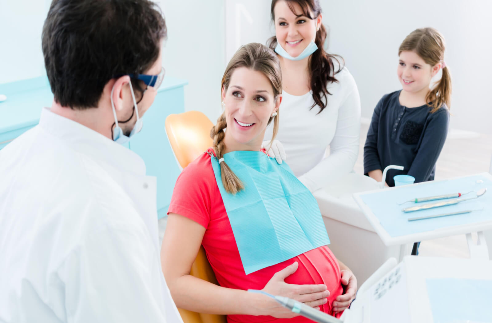 a pregnant woman visits the dentist with her family